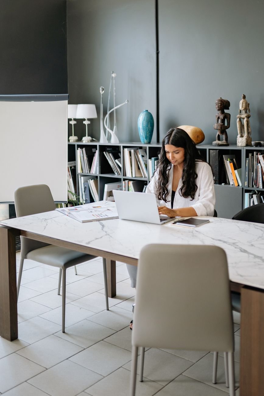 A woman professional working on a laptop, representing a Vridhi investor.